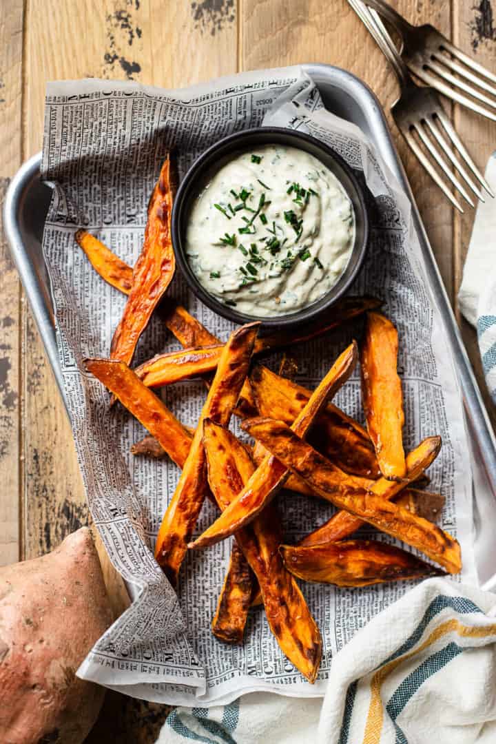 Sweet potato fries recipe made in the oven, with a bowl of Greek yogurt horseradish dijon dip on the side.