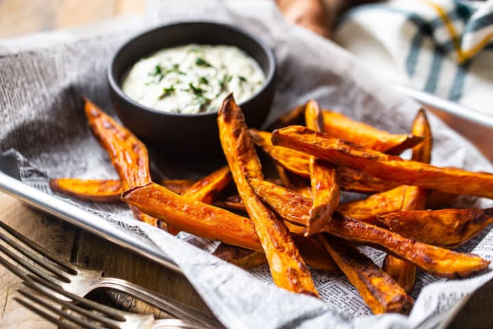 Close up image of how to make sweet potato fries in the oven with a zingy, healthy dip on the side.