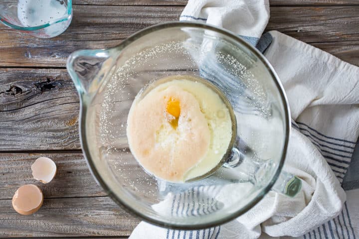 Añadir suero de mantequilla, aceite y huevo a la masa de bollo pegajoso.