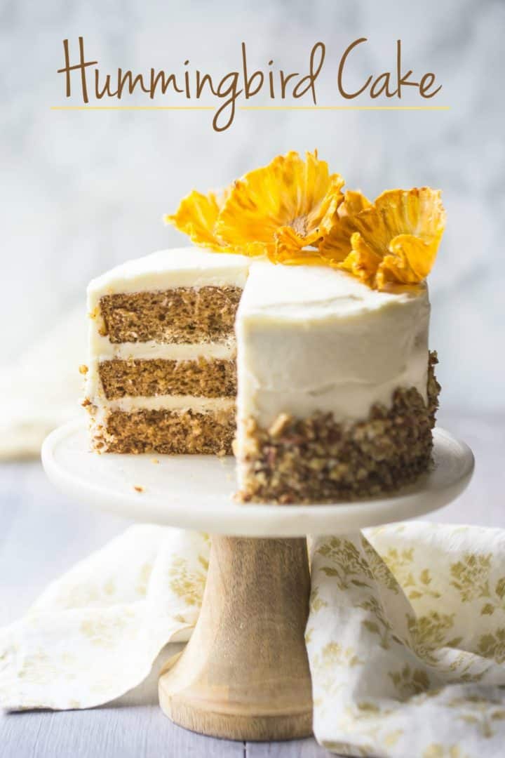 Traditional hummingbird cake on a marble cake pedestal, embellished with pineapple plants.  Hummingbird Cake IMG 3922 classic hummingbird cake text 720x1080