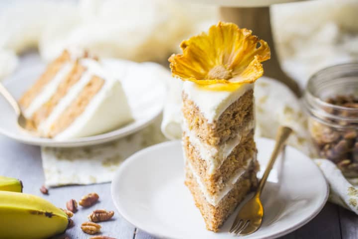 A vertical chop of hummingbird cake, with one more chop in the background that is laid on its aspect.  Hummingbird Cake IMG 3936 old fashioned hummingbird cake recipe 720x480