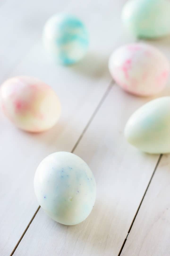 Hard-boiled Easter eggs on a white wooden surface.