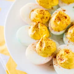 Classic deviled eggs on a white plate with a yellow napkin.