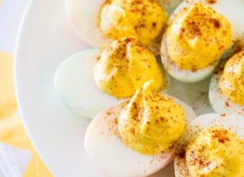 Classic deviled eggs on a white plate with a yellow napkin.