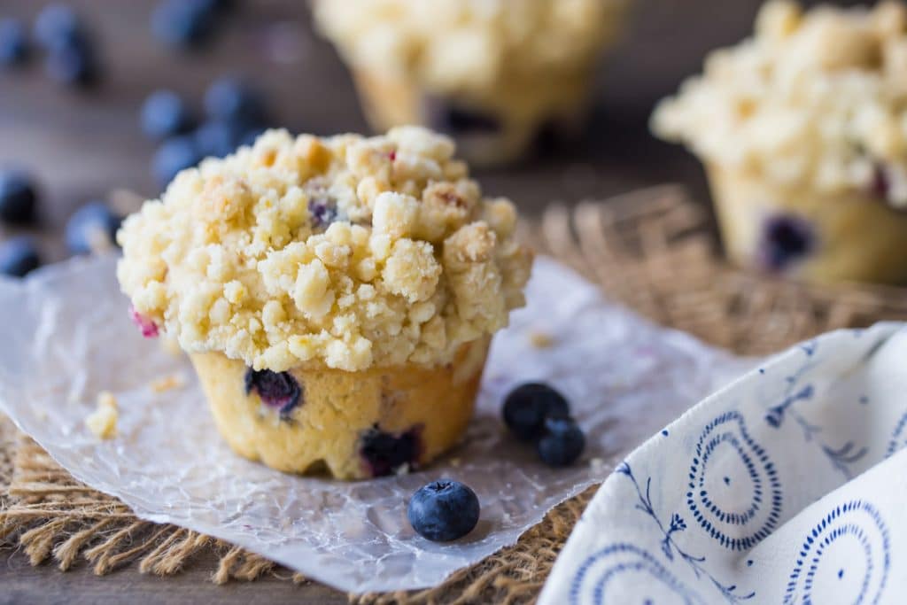 Horizontal image of a homemade blueberry muffin with streusel topping.
