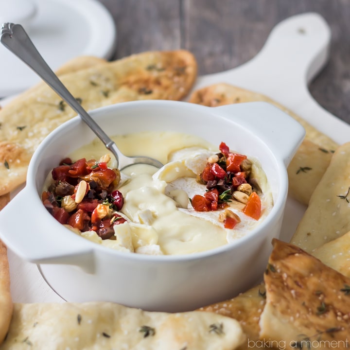 Serve this simple appetizer at your next get-together! The baked cheese is so creamy, and couldn't be easier to make, and the roasted red pepper relish has tons of smoky-sweet flavor! Scoop it all up with crunchy homemade herbed flatbreads. @marthastewart
