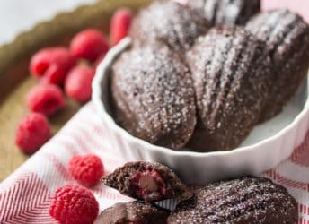 Chocolate Raspberry Madeleines: these little cakes are so perfect for a special occasion! Taste like a cake-y brownie, with a fresh raspberry baked inside. The shell shape couldn't be prettier! #BakeYourPassion #sponsored @whitelilyflour