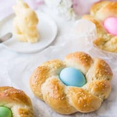 Easter Egg Bread: a golden brown braided loaf with a pastel-colored egg nestled in the middle.