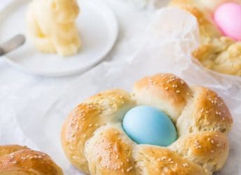 Easter Egg Bread: a golden brown braided loaf with a pastel-colored egg nestled in the middle.