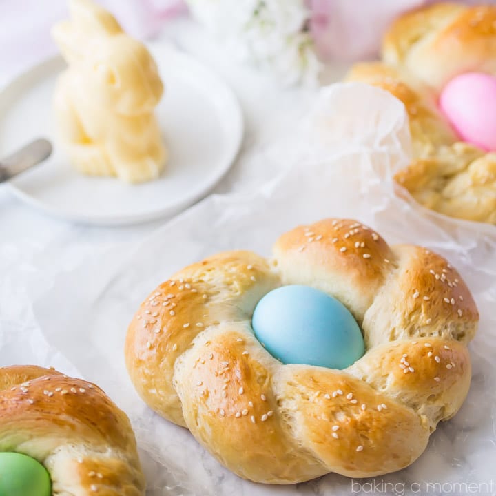 Easter Egg Bread: a golden brown braided loaf with a pastel-colored egg nestled in the middle.  