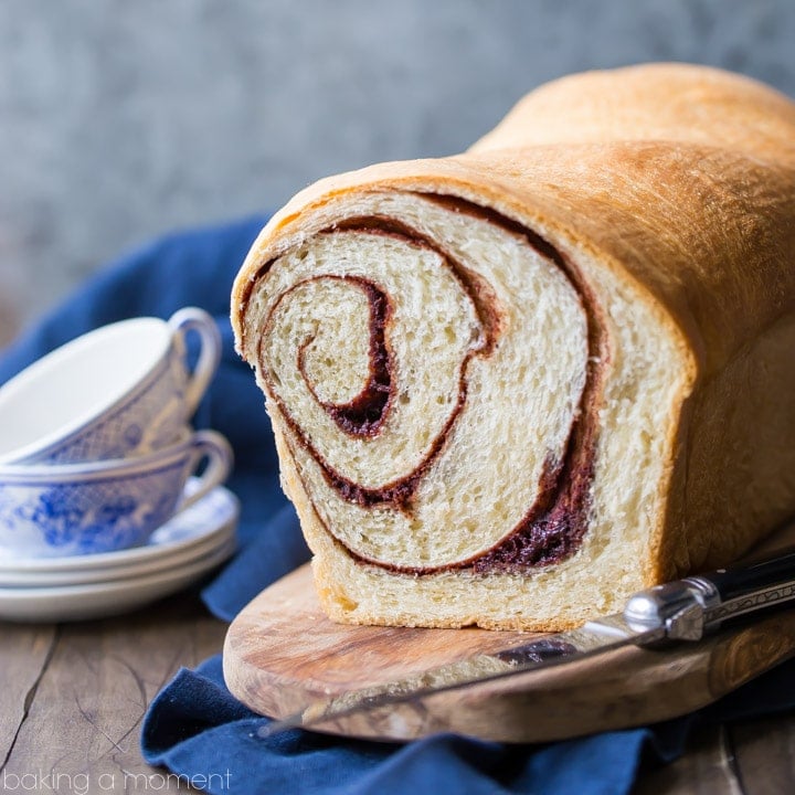 A loaf of cinnamon bread presented cut-side out to display the spiral of cinnamon sugar.