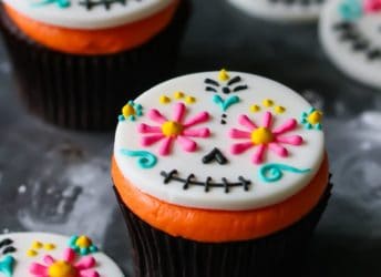 Day of the Dead Cupcakes- colorful fondant topper on a dark chocolate cupcake with bright orange frosting.