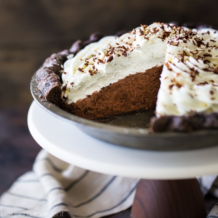 Chocolate Cream Pie with chocolate crust, whipped cream, and chocolate shavings. A slice is taken out of the pie so the fluffy chocolate mousse filling is visible.
