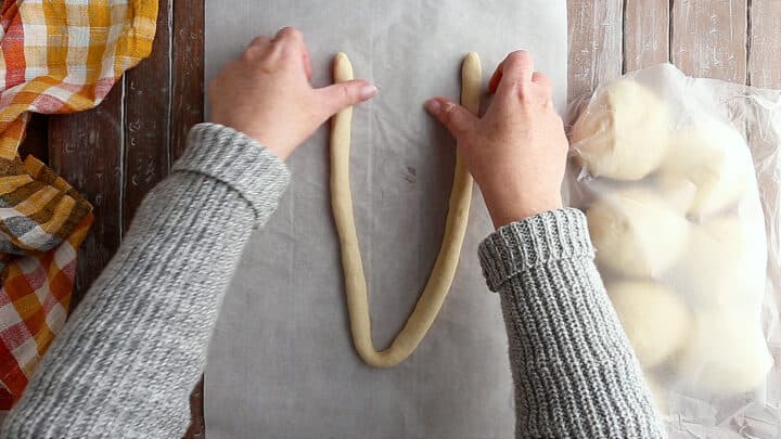 Forming a "U" shape with pretzel dough.