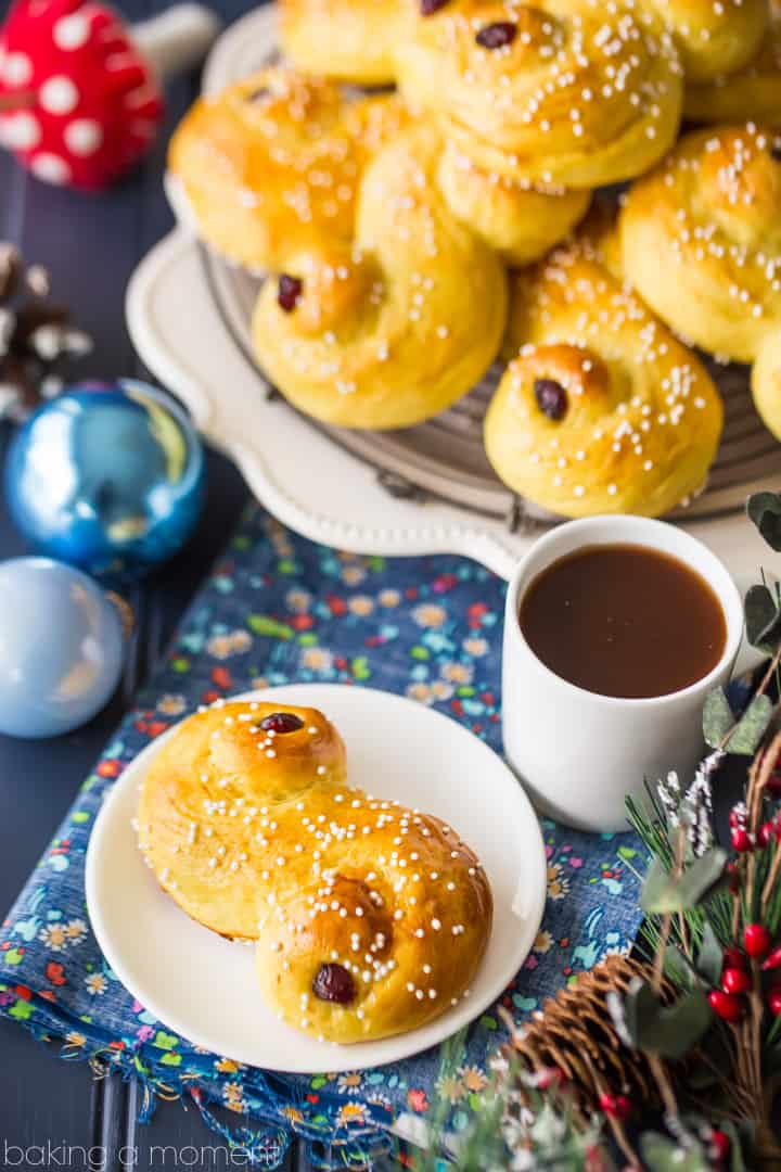 Saffron-scented Lucia Buns, sprinkled with sugar and garnished with dried cranberries. A centuries old Scandanavian tradition- so light and soft, and perfect with a cup of coffee! #food #bread #desserts #baking #swedish #luciabuns #stluciaday #holiday