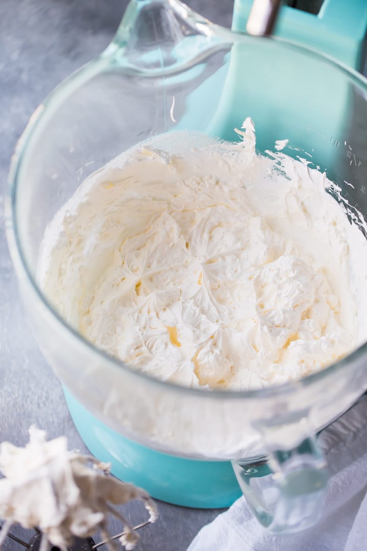 Fluffy Swiss meringue buttercream in the bowl of a stand mixer.