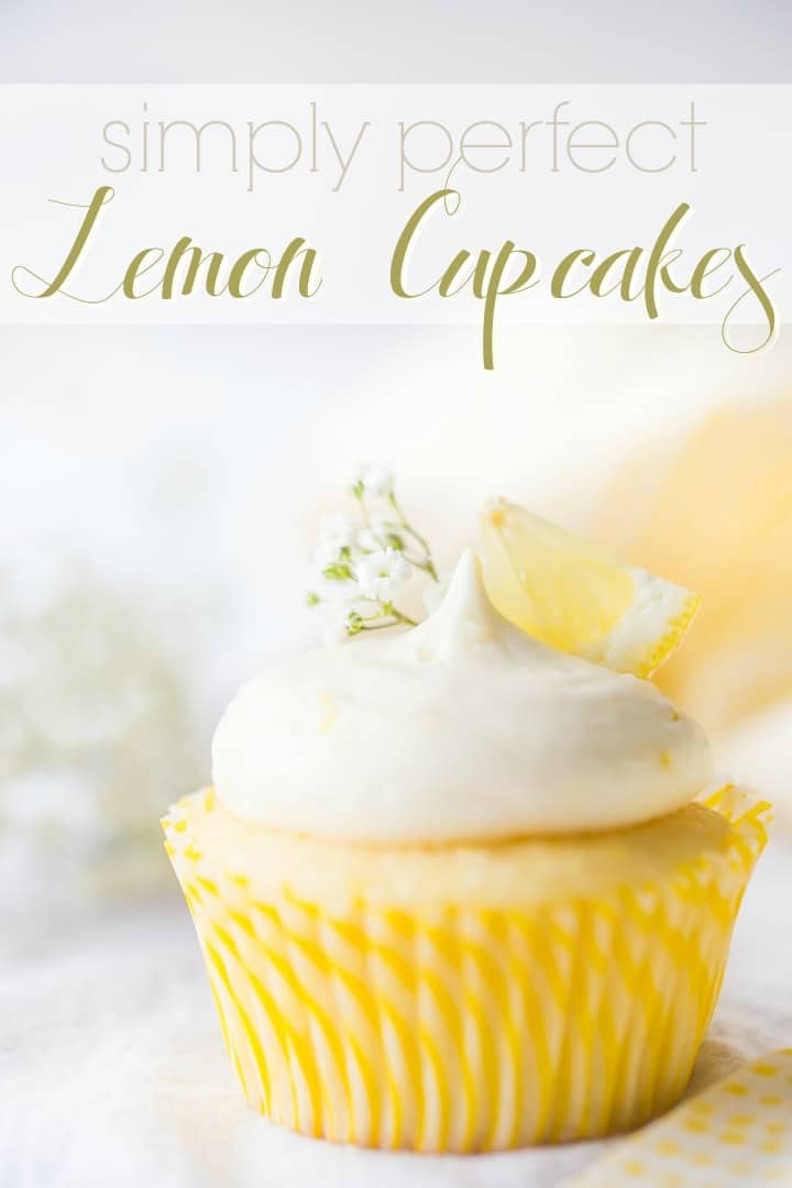 Text overlayed image of a lemon cupcake with lemon curd filling & lemon cream cheese frosting, garnished with baby's breath and a wedge of fresh lemon.