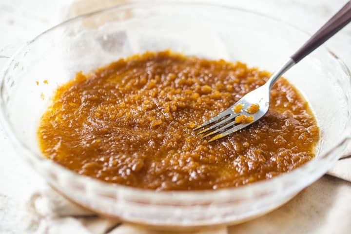 Mixing brown sugar and butter together with a fork.