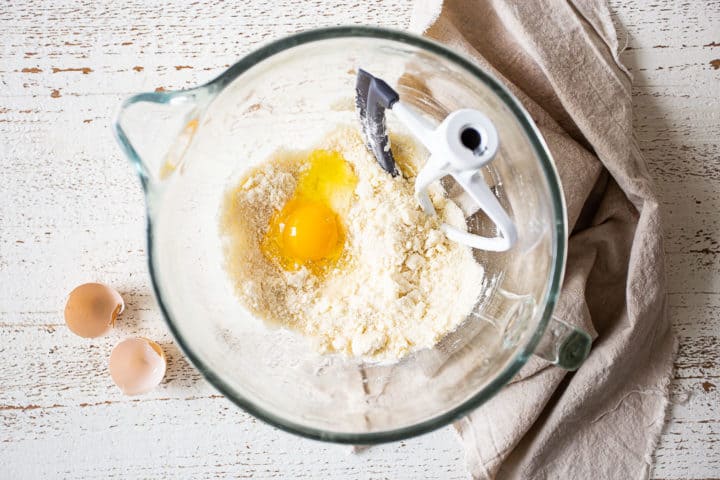 Adding egg to cake batter.
