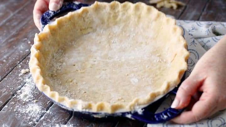 Unbaked pie crust in a pie dish with a crimped edge.