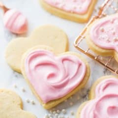 Square image of a heart-shaped soft cut-out sugar cookie with pink sour cream icing.