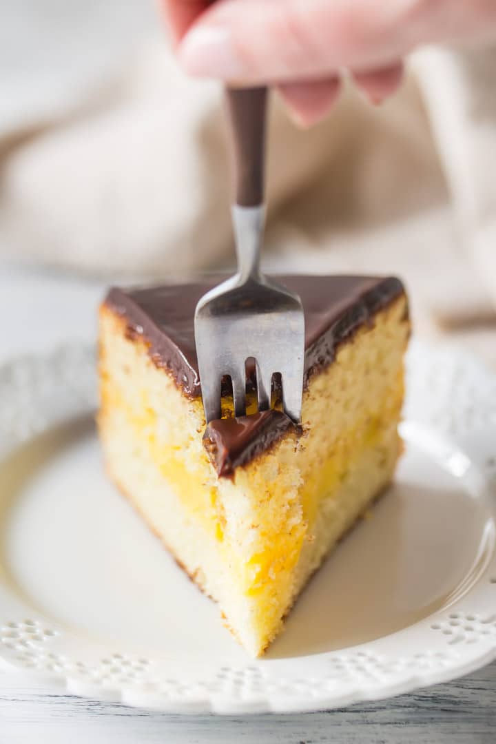 Sinking a fork into a slice of homemade Boston Cream Pie.