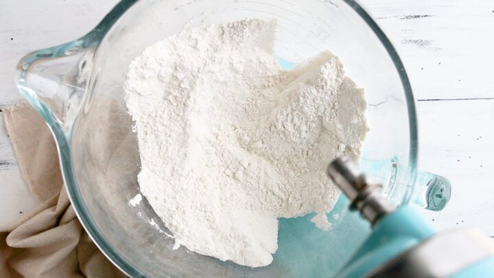 Dry ingredients for vanilla cake blended together in the bowl of a stand mixer.