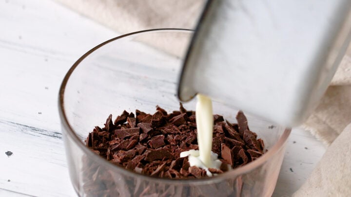 Pouring hot cream over chopped chocolate.