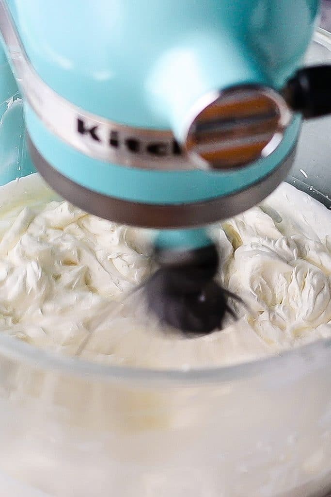 Fluffy cream cheese whipped cream in a glass mixing bowl.