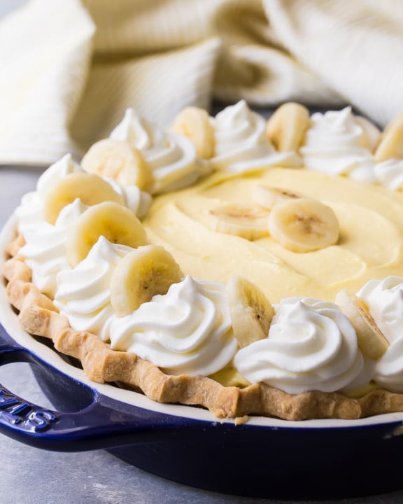 Banana Cream Pie with fluffy custard, swirls of whipped cream, and fresh bananas.