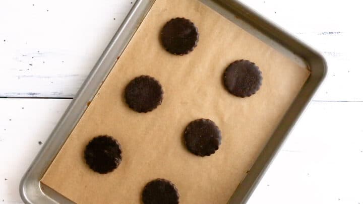 Unbaked homemade Oreos on a parchment-lined baking sheet.