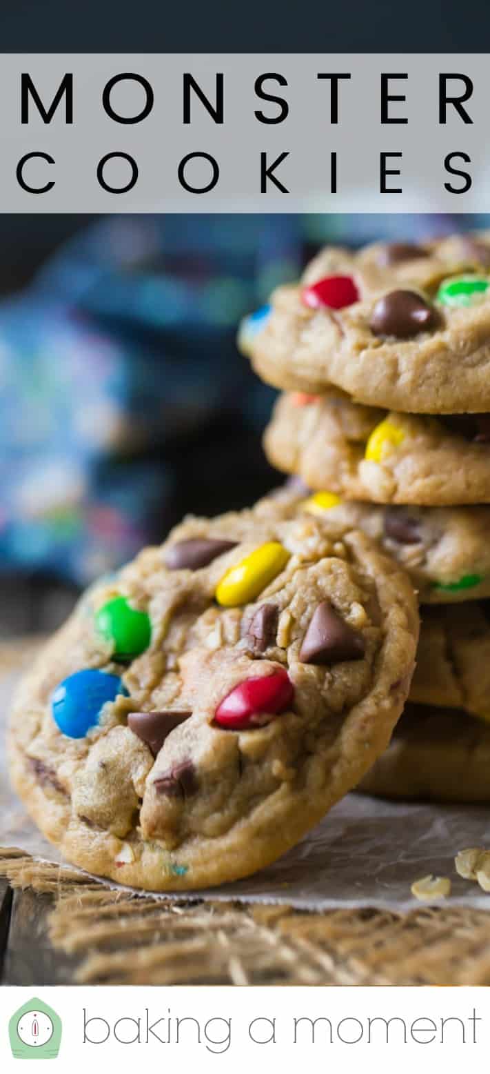 Close-up of a stack of soft monster cookies with oatmeal and m&m's, with a text overlay above that reads "Monster Cookies."