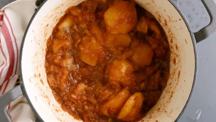 Cooking apple butter ingredients together in a large pot.