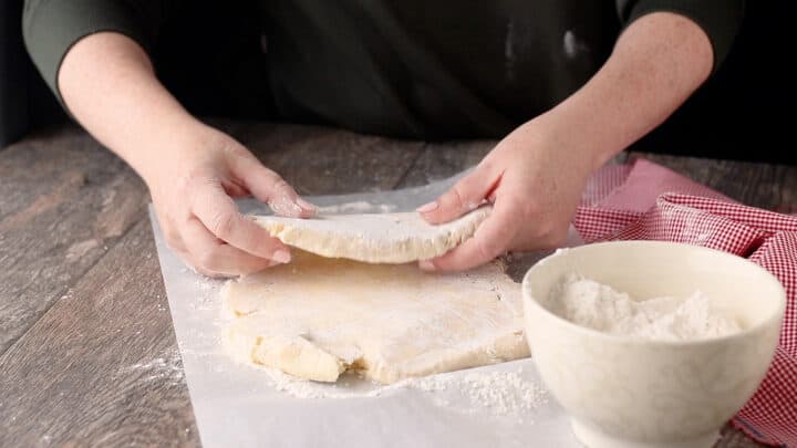 Folding puff pastry dough into thirds.