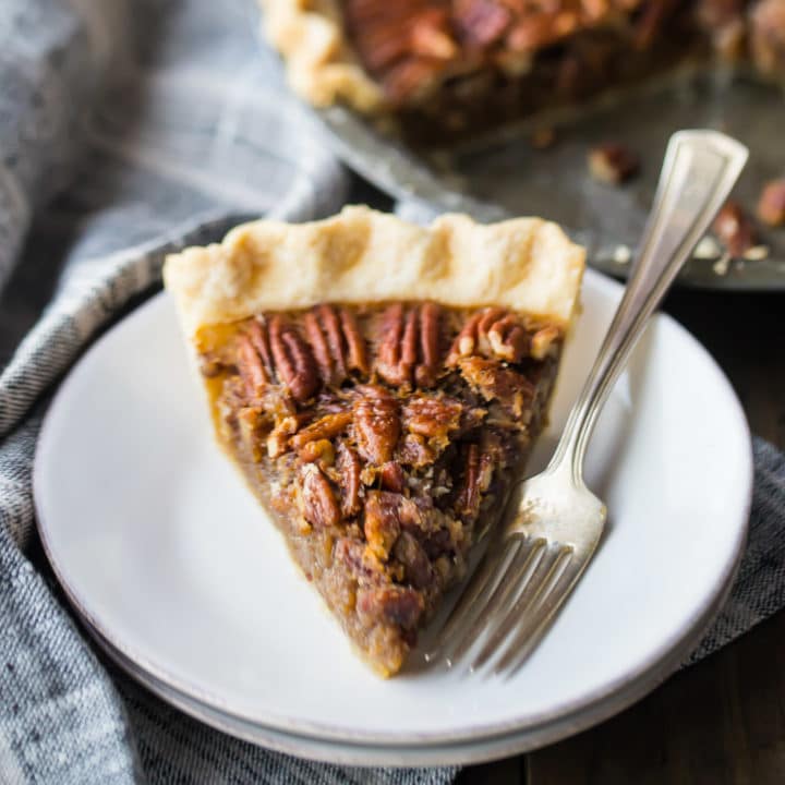 Perfect slice of pecan pie, served on a cream stoneware plate.