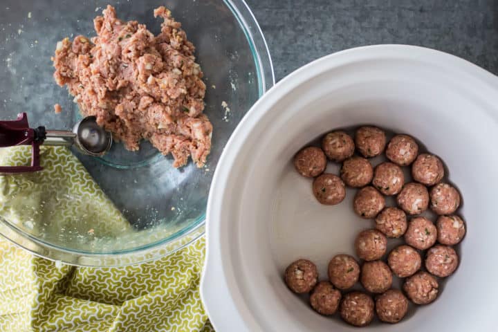 Rolling meatballs and placing them in a crock pot