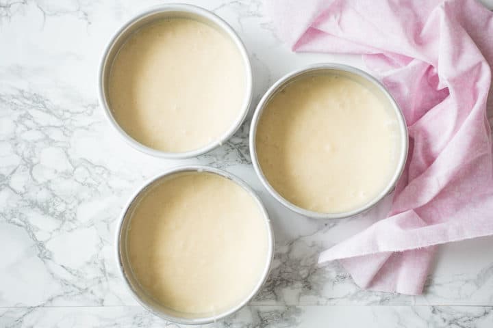 White almond sour cream cake batter in 3 pans.