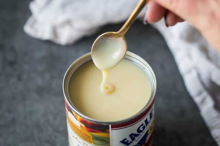 Can of sweetened condensed milk on a dark gray background.