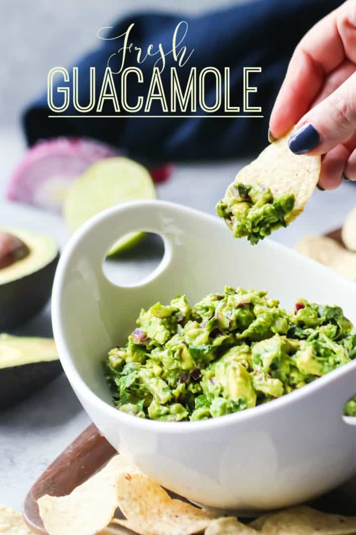 Tortilla chip scooping guacamole out of a bowl, with text overlay reading "Fresh Guacamole."