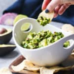 Dipping a corn chip into a bowl of simple guacamole.