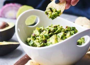 Dipping a corn chip into a bowl of simple guacamole.