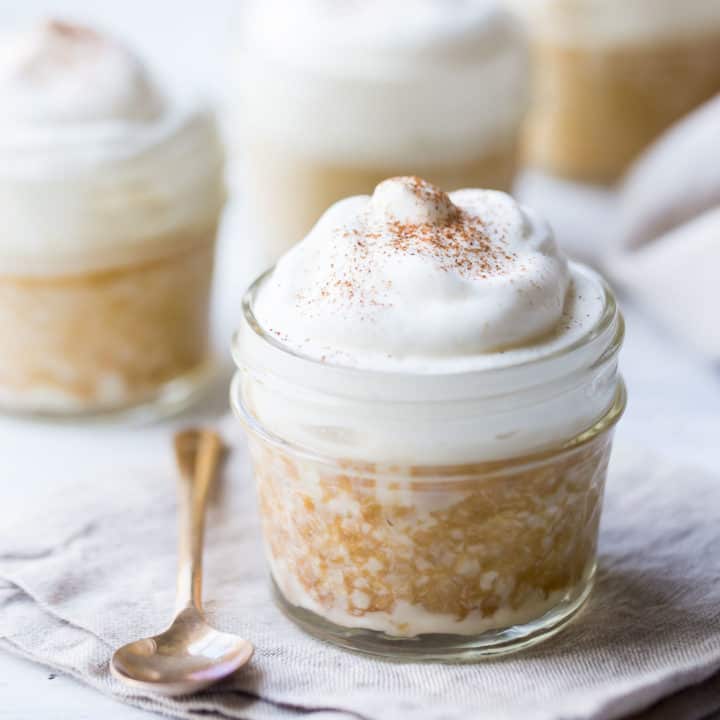 Tres leches cake baked in a small jar, topped with whipped cream.