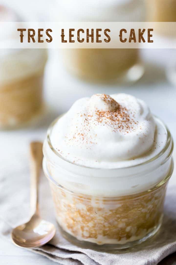 Tres leches cake with whipped cream in a small jar with a text overlay above reading "Tres Leches Cake."