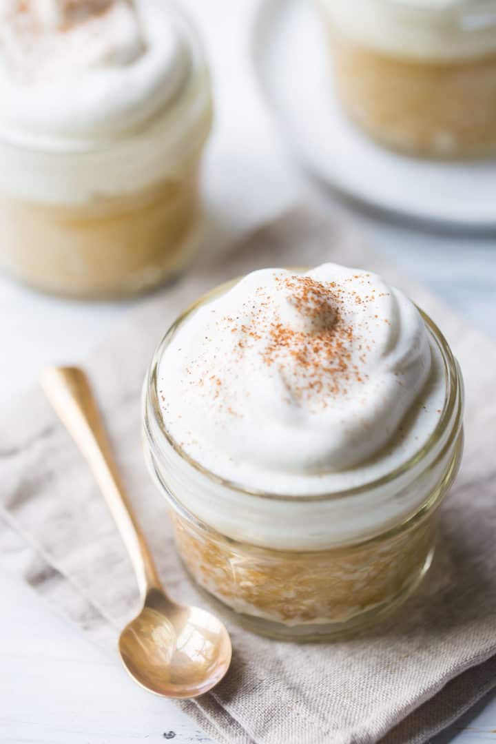 Tres leches cake baked in a jar with a gold spoon and a linen napkin.