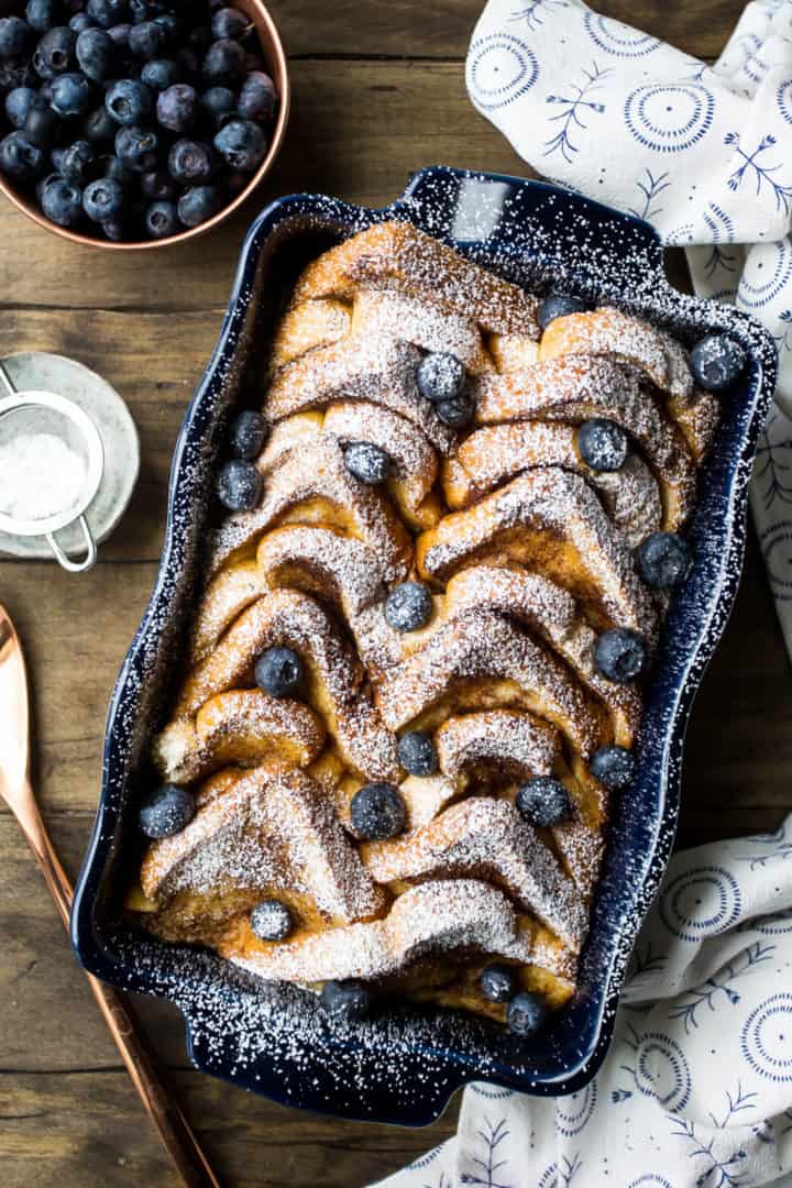Overhead view of easy baked French toast casserole with powdered sugar and blueberries.