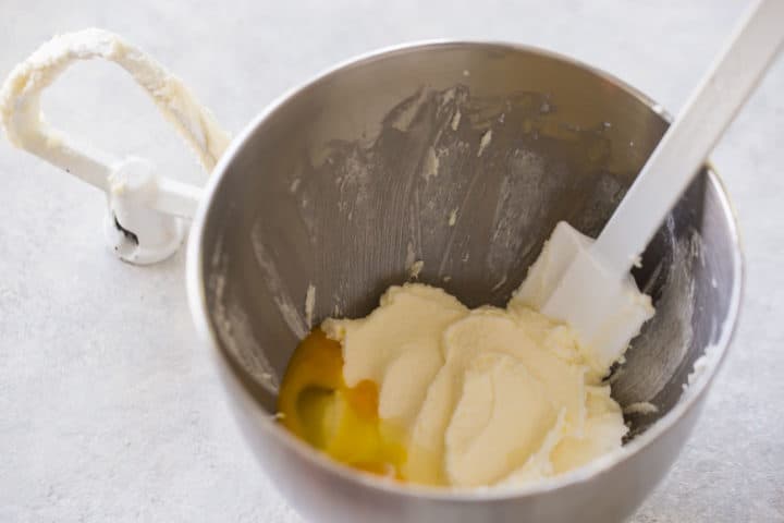 Fluffy creamed butter and sugar in a mixing bowl, with eggs.