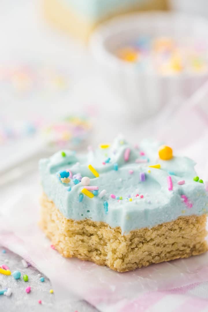 Close-up of a sugar cookie bar with cream cheese frosting and sprinkles.