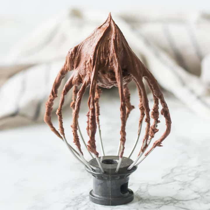 Whisk attachment from a stand mixer with stiffly whipped chocolate ganache.
