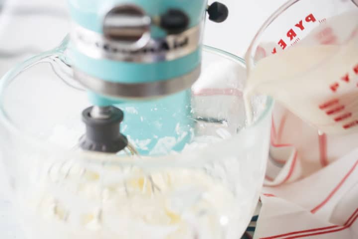 Drizzling cream into whipped cream frosting.
