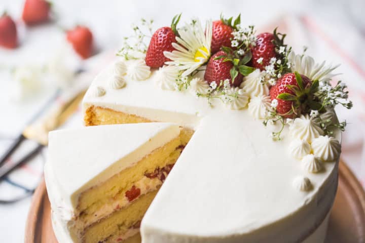 Strawberry shortcake birthday cake decorated with fresh flowers and strawberries.